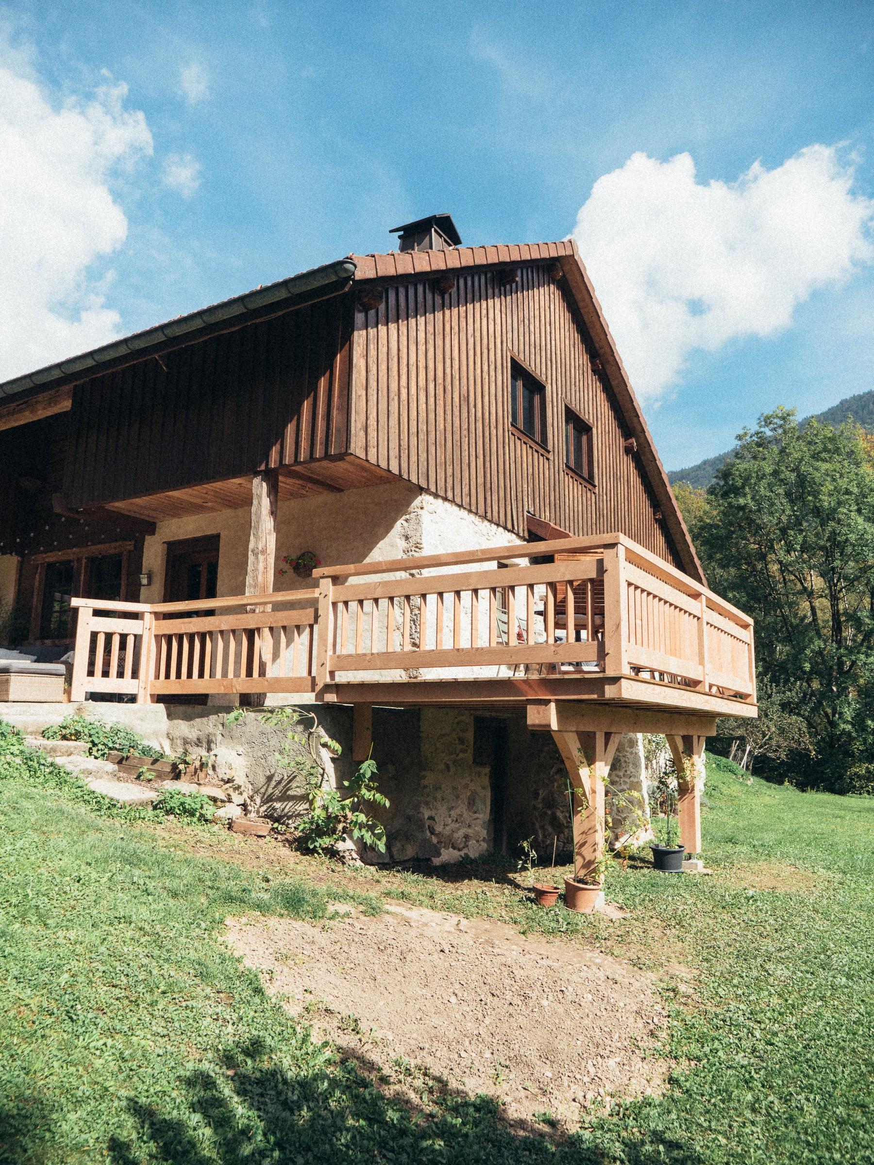 Ancienne ferme en pierre et bois dotée d’un balcon en bois par Aravis Menuiserie