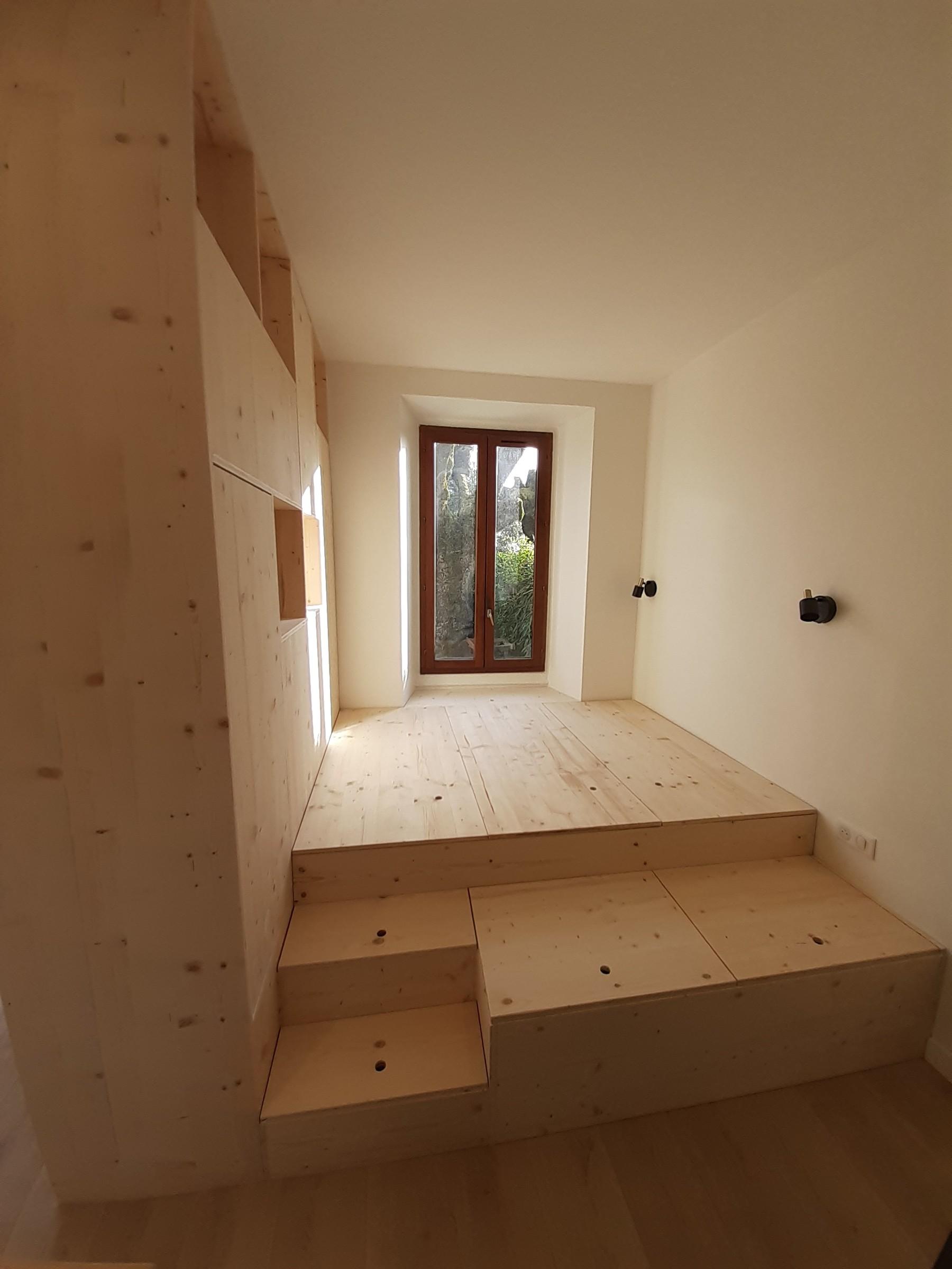 Chambre avec estrade et rangements intégrés, réalisée par Aravis Menuiserie