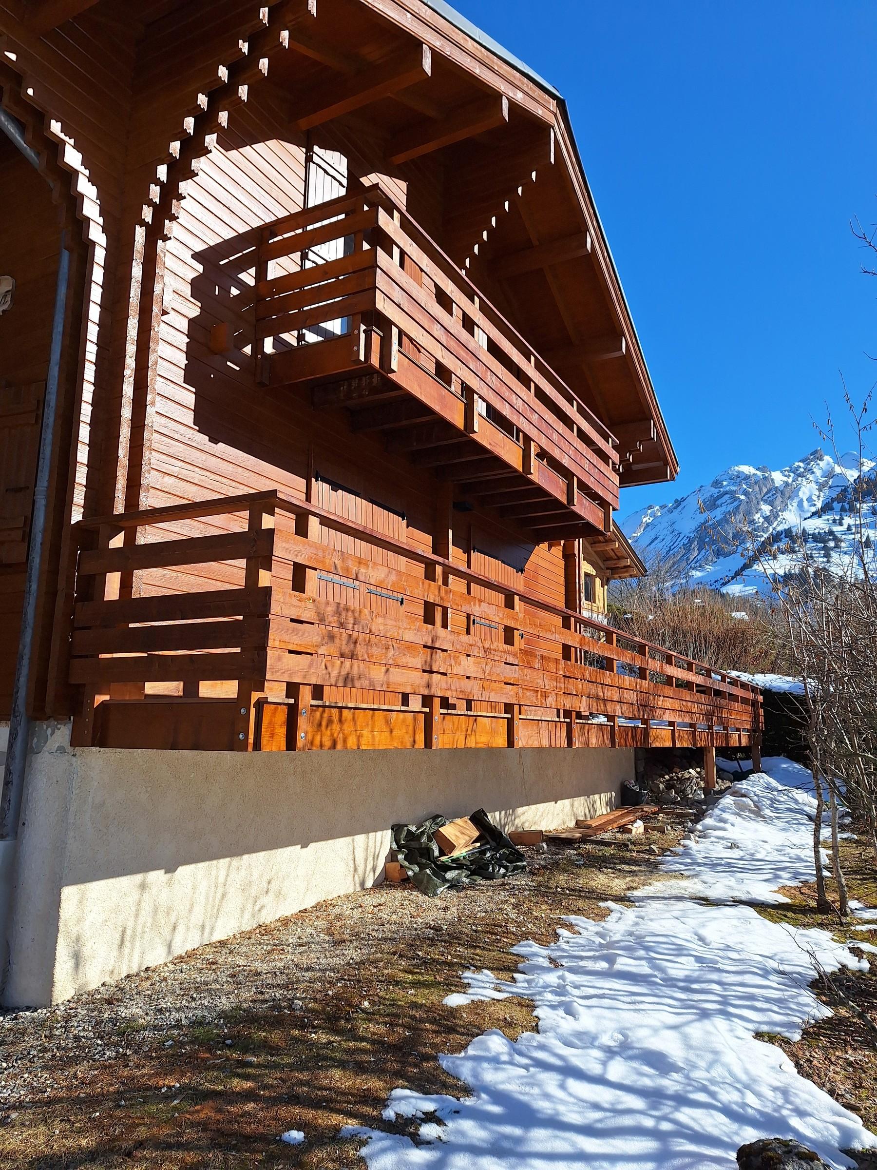 Chalet aux balcons en bois rénovés par Aravis Menuiserie