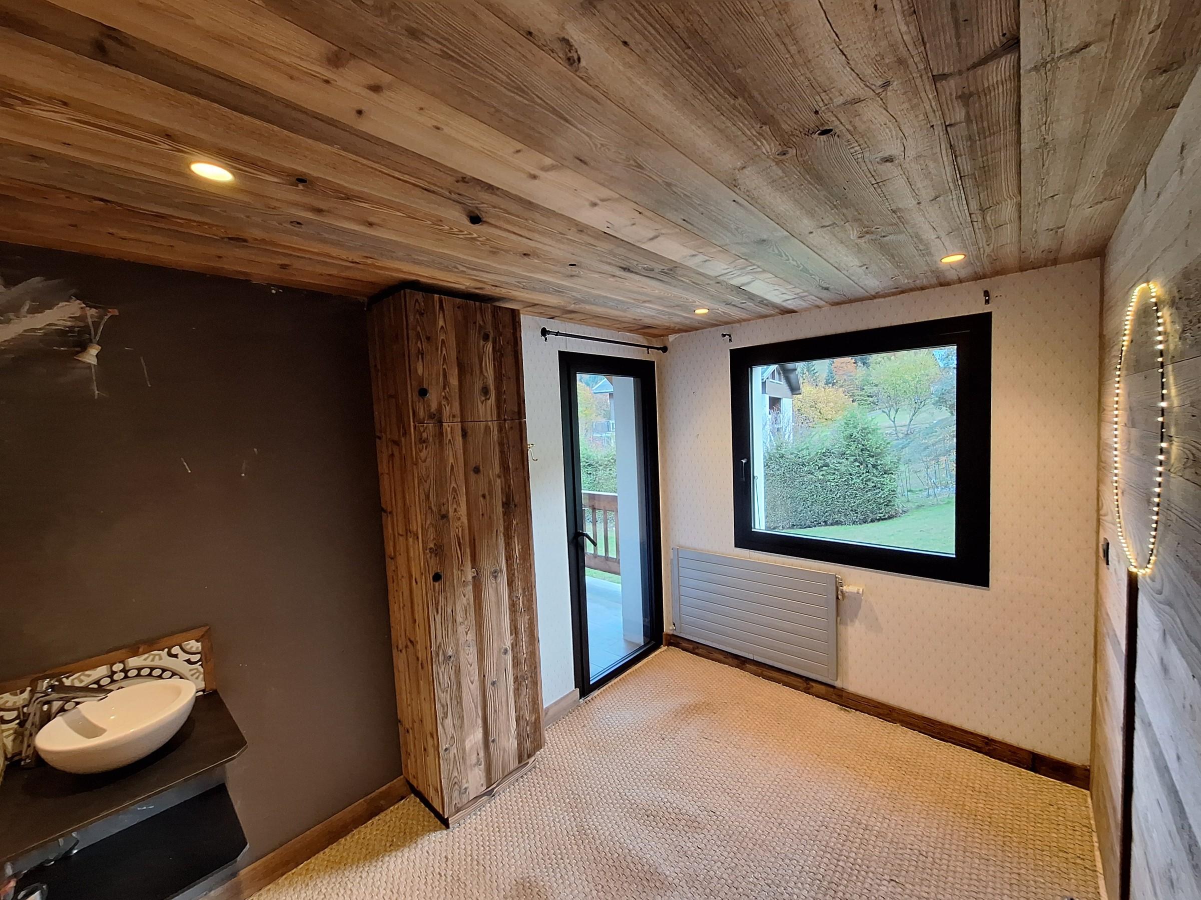 Intérieur de chalet rénové avec habillage en bois vieilli, par Aravis Menuiserie